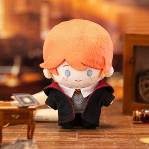 Harry Potter Magic Academy Cotton Doll with Hogwarts student uniform against orange background. Officially licensed collectible with authentic wizarding world details.