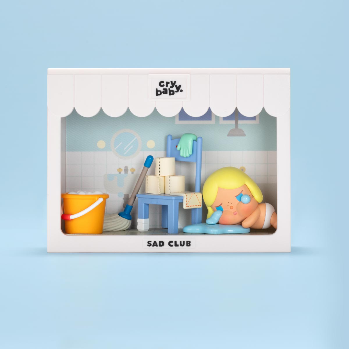CRYBABY Sad Club Series living room diorama with light blue background showcasing detailed miniature furniture and emotional characters. Collectible scene set with storytelling elements.
