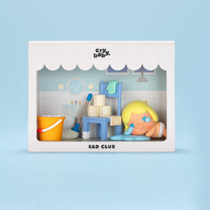 CRYBABY Sad Club Series living room diorama with light blue background showcasing detailed miniature furniture and emotional characters. Collectible scene set with storytelling elements.